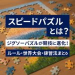 「スピードパズルとは？」という文字が目立つアイキャッチ画像。背景には木製テーブルの上で組み立て途中のジグソーパズルが映っており、「ジグソーパズルが競技に進化！」「ルール・世界大会・練習法まとめ」といったテキストが重ねられている。